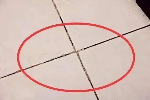 墙面瓷砖缝隙处出现细微裂纹的特写,说明水泥填缝剂容易开裂的缺点