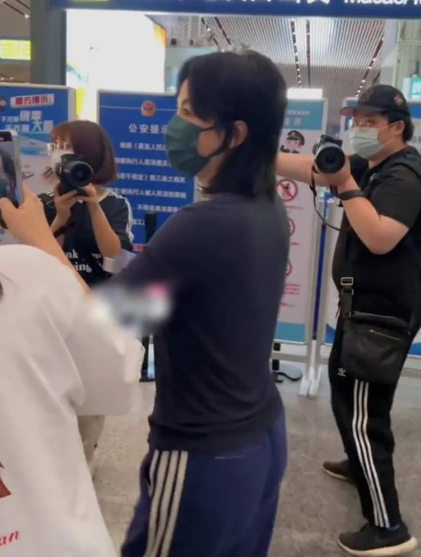 王菲身穿黑色T恤蓝色条纹裤在机场与粉丝互动