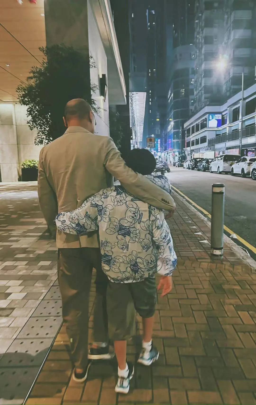 邓莎晒出的路行与儿子散步背影照,光头造型引人注目